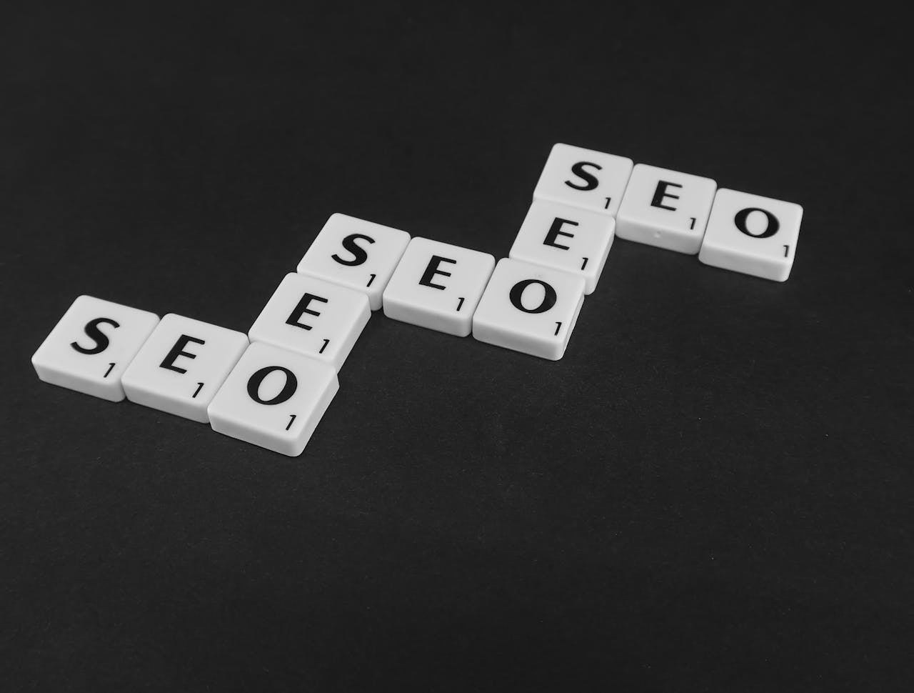 our-story SEO spelled with Scrabble tiles on a black surface, representing search engine optimization concepts.